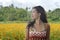 Young Asian Chinese tourist woman enjoying relaxed the view of a beautiful flowers field landscape during a journey excursion in h