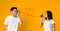 Young asian couple with can phone on orange background