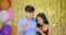 Young asian couple enjoy with confetti over gold glitter background.