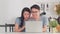 Young Asian couple enjoy shopping online on laptop at home. Lifestyle young husband and wife happy buy ecommerce after have