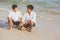 Young asian couple gay smiling romantic drawing heart shape together on sand in vacation