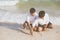 Young asian couple gay smiling romantic drawing heart shape together on sand in vacation