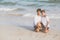 Young asian couple gay smiling romantic drawing word text love together on sand in vacation