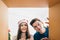 Young Asian couple opening a Christmas present together with a smile, views from inside of the box with a decorated Christmas tree