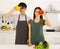 Young Asian couple preparing food in modern kitchen covering their eyes with yellow and red capsicum smiling and look at the