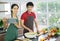 Young Asian couple. Standing smile cooking in the kitchen. prepare salad for food together happily.