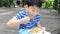 Young asian cute boy eating fried chiness noodles in foam box