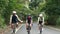 young asian cyclists riding bicycles on rural road