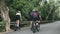 young asian cyclists riding bike on rural road