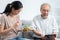 Young Asian daughter serving and feeding food to senior father