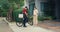 Young Asian delivery man with bicycle in red uniform carry case box knock door home online shopping paper bag to woman in front of