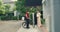 Young Asian delivery man with bicycle in red uniform carry case box knock door home online shopping paper bag to woman in front of