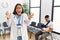 Young asian doctor woman at waiting room with a man with a broken arm celebrating mad and crazy for success with arms raised and