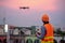 Young Asian engineer flying drone over construction site