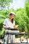 Young Asian female at the campground, preparing barbecue picnic party food, grilling a steak