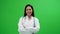 Young Asian female doctor portrait standing with arms folded over Green Screen background