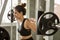 young asian fitness woman in sportswear exercising building muscles lifting weight with barbell in gym. sport girl workout healthy