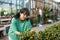 Young asian girl choosing ornamental potted kumquat in greenhouse