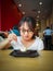 A young asian girl enjoying Brownie with vanilla ice cream served on a plate at a restaurant