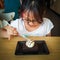 A young asian girl enjoying Brownie with vanilla ice cream served on a plate at a restaurant