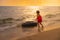 The young asian girl funny playing swim ring on the beach at the sunset