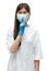 Young asian girl in medical mask and blue gloves show silence sign on white background