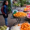 Young Asian girl sells fruit on a city street