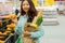 Young Asian girl shopping in a supermarket. Woman buys fruit and dairy product.