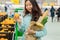 Young Asian girl shopping in a supermarket. Woman buys fruit and dairy product.