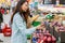 Young Asian girl shopping in a supermarket. Woman buys fruit and dairy product.