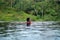 Young Asian Girl swimming in the infinity pool with beautiful view. She is taken photos from the back