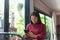 Young Asian girl using phone at a coffee shop .Woman happy on smartphone in cafe.