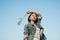 Young asian girl wear Jetket Jean hold grass flower .Blue sky background