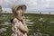 A young Asian girl wearing a beach hat is relaxing on the blue sky beach at Gunungkidul, Indonesia