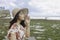 A young Asian girl wearing a beach hat is relaxing on the blue sky beach at Gunungkidul, Indonesia