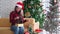 Young Asian girl wearing Santa hat opening Christmas gift in Christmas Holiday