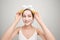 Young Asian having white facial clay mask and holding orange piece