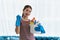 Young Asian housewife wearing gloves and holding basket with cleaners and brushes, cleaning and washing concept