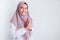 Young Asian Islam woman wearing headscarf gives greeting hands at with a big smile on her face. Indonesian woman on gray