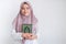 Young Asian Islam woman wearing headscarf is holding holy al quran in hand with smile and happy face. Indonesian woman on gray