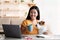Young asian lady freelancer having coffee break, holding puppy