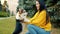 Young Asian lady playing with beautiful corgi puppy in park hugging animal