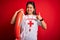 Young asian lifeguard girl wearing t-shirt with red cross using whistle holding orange float happy with big smile doing ok sign,