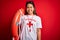Young asian lifeguard girl wearing t-shirt with red cross using whistle holding orange float with a happy face standing and