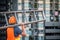 Young Asian maintenance worker carrying aluminium ladder