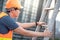 Young Asian maintenance worker man carrying aluminium ladder