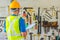 Young Asian male engineer or architect holding files wearing protective safety helmet near the many different rusty old tools