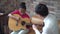 Young Asian male teacher giving a guitar lesson and teaching how to play guitar to African American girl