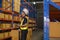 Young asian male worker wearing helmet using talki walki in modern warehouse