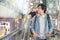 Young Asian man with airport trolley on escalator